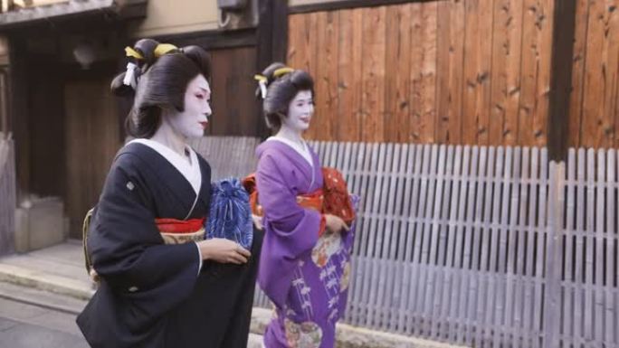 两名艺妓妇女一起走在京都Gion的街道上