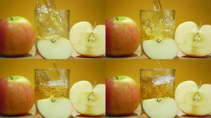 将新鲜的苹果汁倒入慢动作的黄色背景上的玻璃杯中