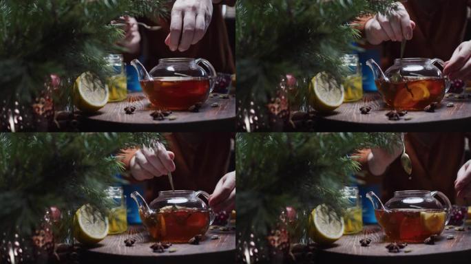 人类的手正在准备带有柠檬和蜂蜜的圣诞节风味茶