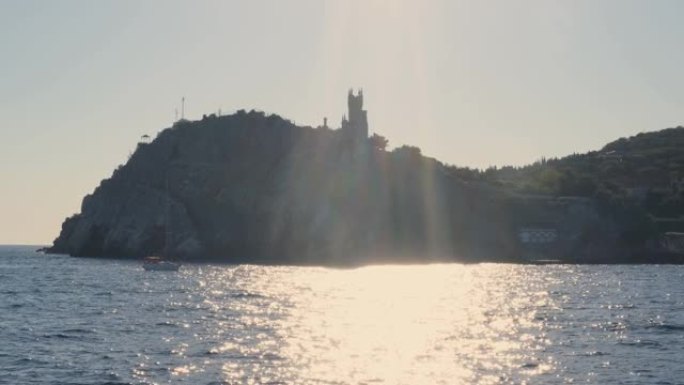 日落时从游船上拍摄的克里米亚雅尔塔燕子城堡的美丽海岸景色