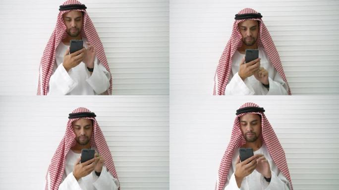 阿拉伯商人专业持有现代智能手机，用于浏览互联网查找社交信息或下载应用程序。在新常态下，在社交距离之间