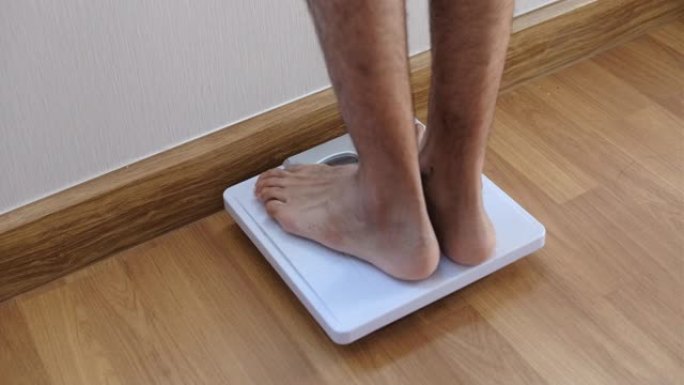 特写脚男人体重秤，用于测量体重减轻。体重秤以健康减肥概念。