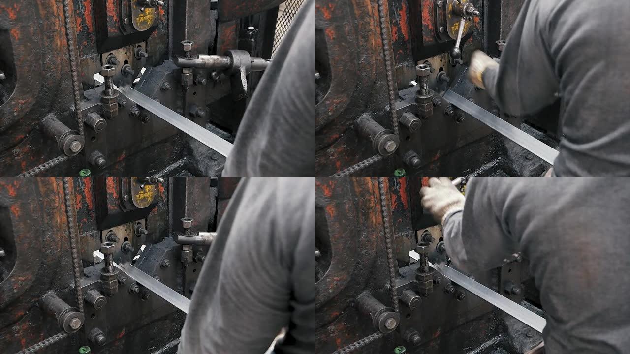 金属冲孔机由工厂液压炼铁工人切割角钢。旧行业概念。