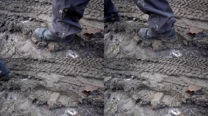 穿着工作靴的工人走进泥泞，在泥泞中留下脚印