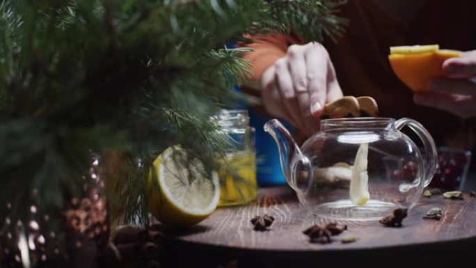 人类的手正在准备带有柠檬和蜂蜜的圣诞节风味茶