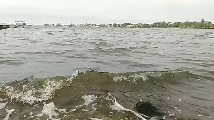 在湖里阴天，海浪的缓慢运动导致飞溅在岩石上。自然背景。