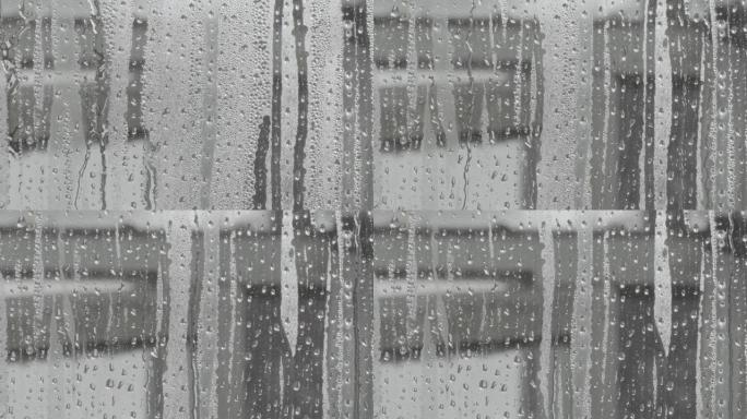 水滴溅到玻璃上。雨天的窗户。湿玻璃，有大滴水或雨水。大雨时在透明玻璃表面上的水滴视频。滴水