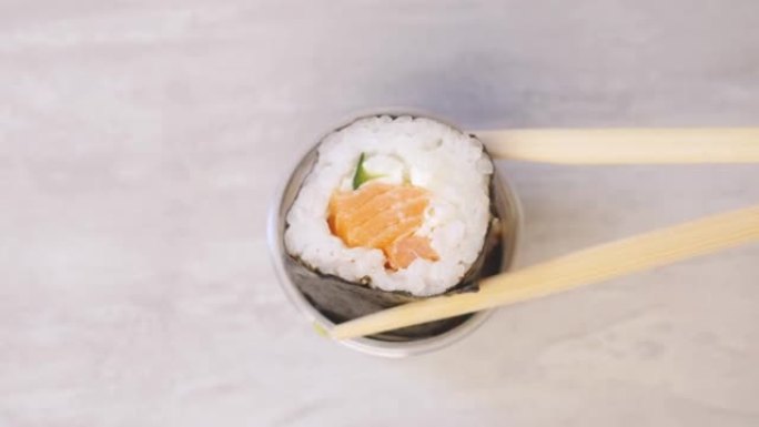用筷子拿着寿司放入酱油