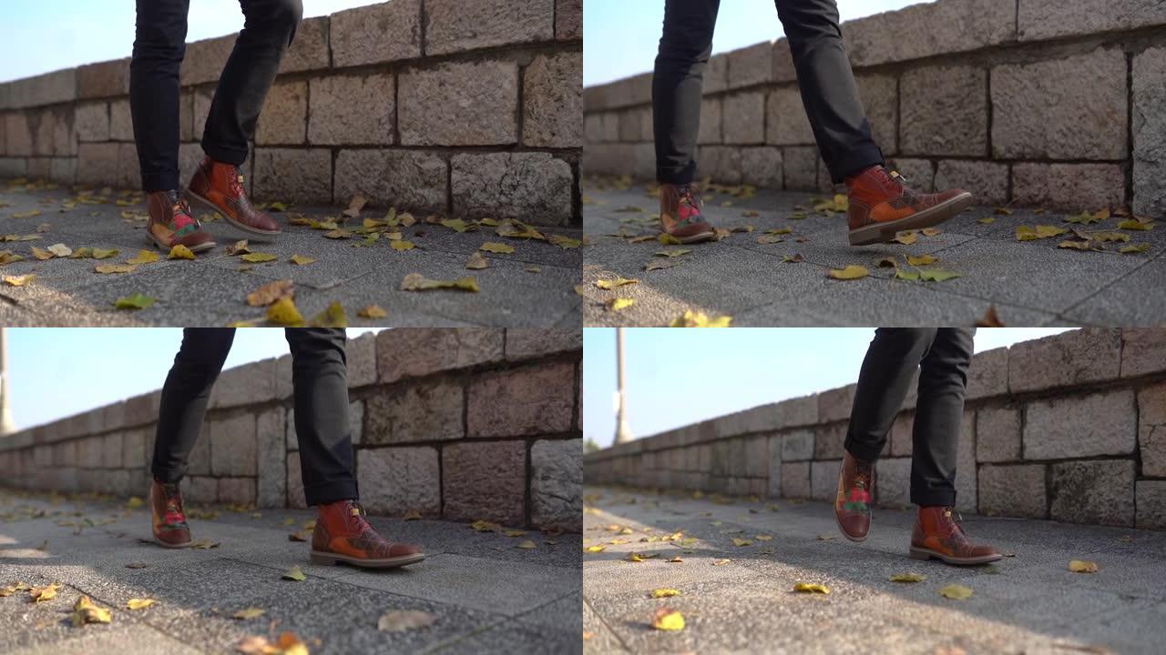 在阳光明媚的秋天，穿着名牌鞋的男人在城市行走