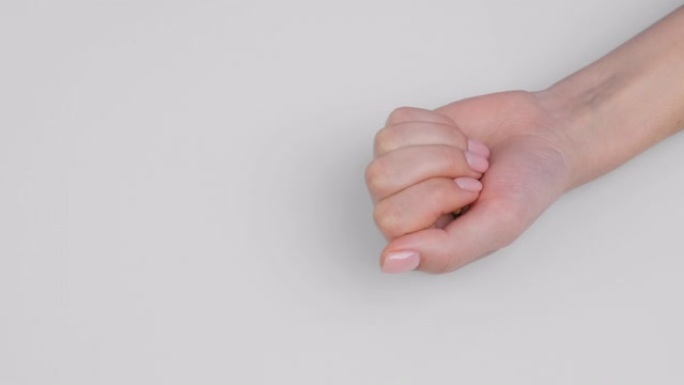女人的手握紧拳头解开手掌丸，胶囊凝胶壳对角线白色背景。欧米茄3，多种维生素，钙，抗生素。健康，复杂的