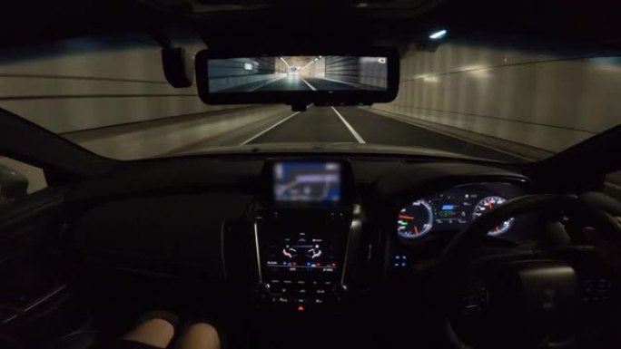 公路旅行中的夫妇，车辆视点通过隧道行驶，驾驶员视点的宽图像视图