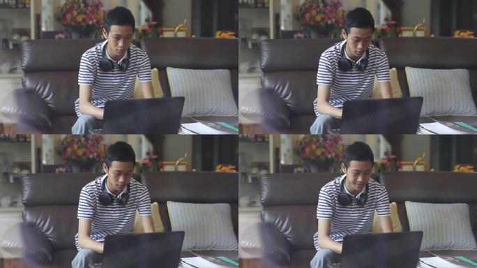 亚洲男孩在家使用电脑笔记本电脑的真实场景