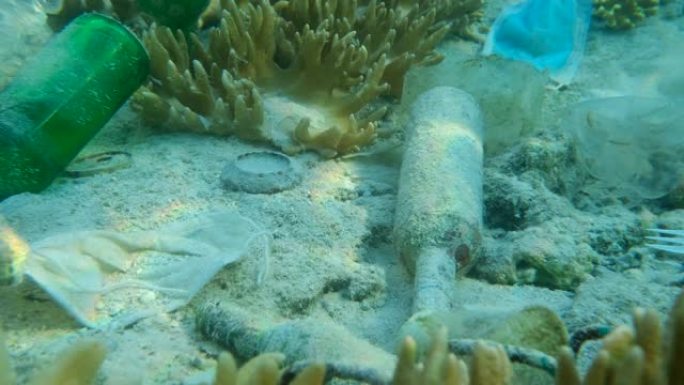 珊瑚海底碎片的特写。塑料和其他垃圾位于海底。