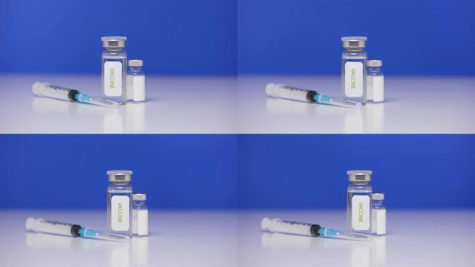 背景实验室桌上的冠状病毒疫苗瓶。注射器特写新型冠状病毒肺炎。击败冠状病毒的概念。蓝屏，色度键。特写。