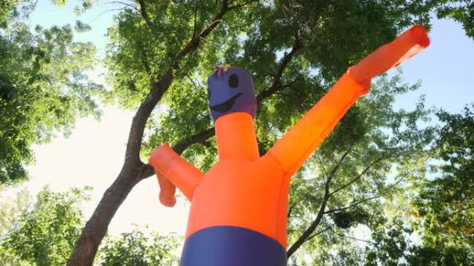 航空通用广告标志。充气橙色古怪舞者管男子挥舞手臂邀请到城市公园度过万圣节。古怪的挥舞充气管子的人。冒