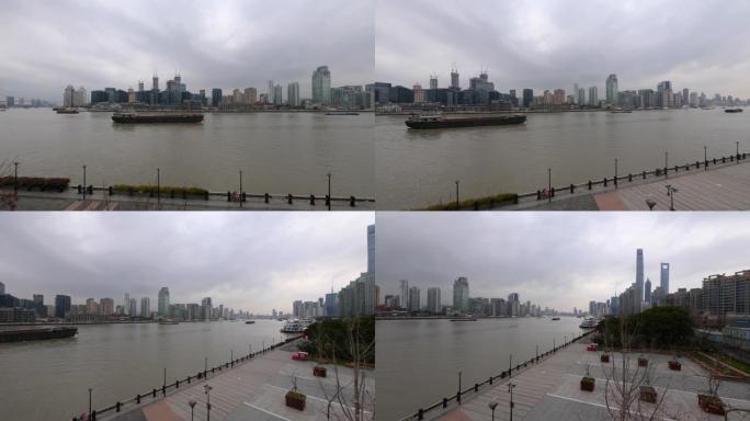 在黄浦江上航行的货船，外滩建筑背景，4k慢动作镜头，宽镜头b翻盘拍摄视频。