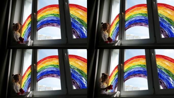 小女孩在窗户上画彩虹的背景。孩子们在家里休闲。居家隔离期间的积极视觉支持