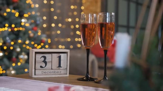木块日历和两杯香槟放在桌子上。假日倒计时
