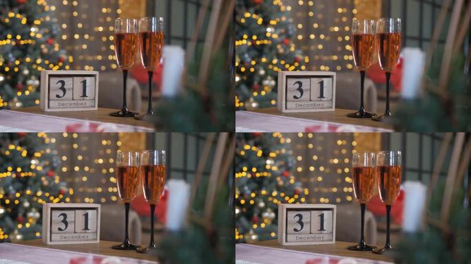木块日历和两杯香槟放在桌子上。假日倒计时
