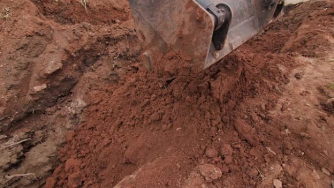 挖掘机桶在施工现场的埋孔上移动