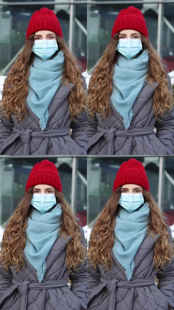 站在街上的医用口罩上的年轻卷发女性肖像的垂直镜头。大流行性流感电晕病毒。疫情冠状病毒。人群患病新型冠