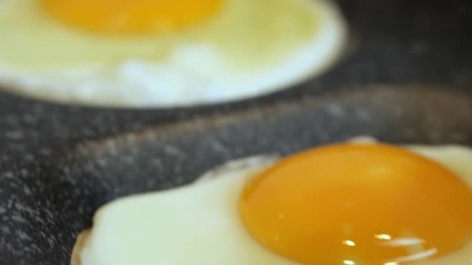 烹饪煎鸡蛋在平底锅上阳光朝上，鸡蛋仅在一侧油炸。蛋黄仍然是完全液态的，表面的白色几乎没有固定。