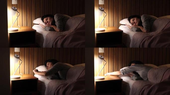 女人躺在床上睡觉前思考。关闭床头灯的人