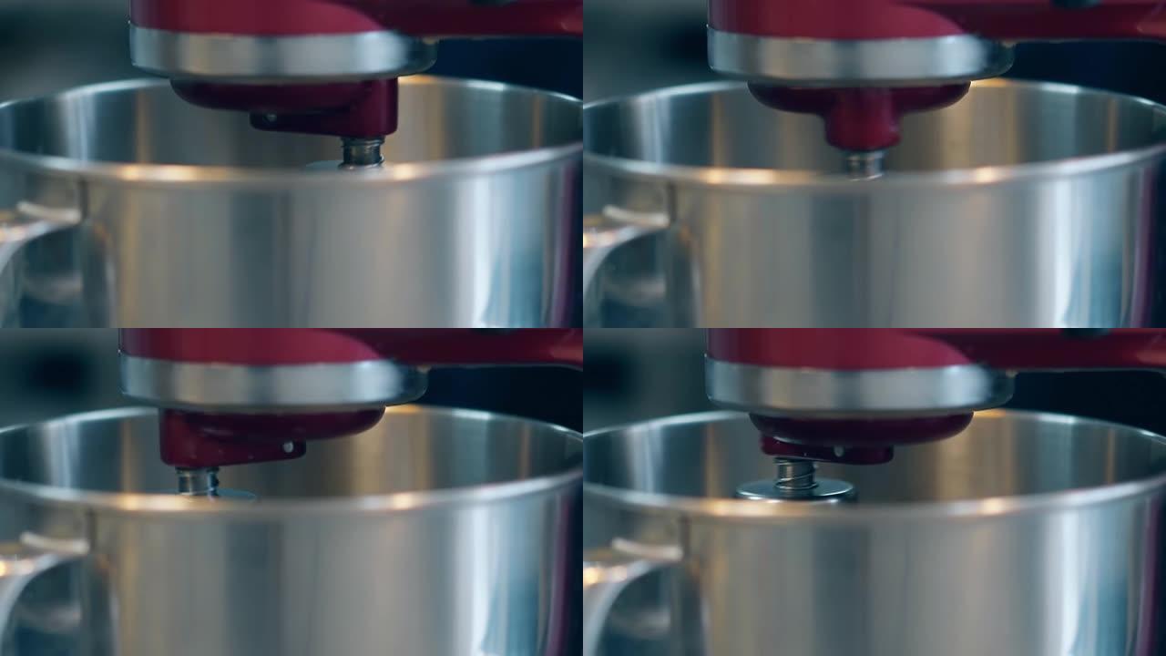 搅拌机逐渐在大金属碗中旋转以准备奶油