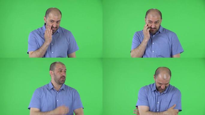 一个中年男子直视镜头的肖像在说哎呀和困惑。秃顶的男性，留着蓝色衬衫的胡须在工作室的绿色屏幕上摆姿势。