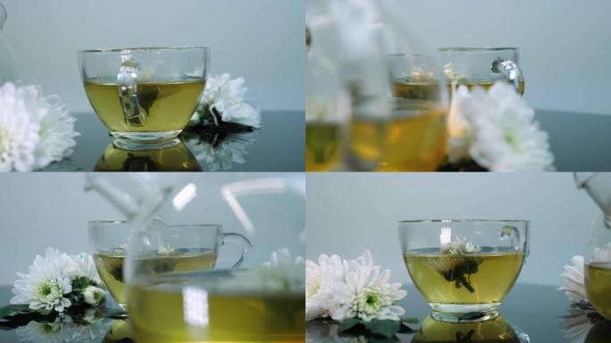 玻璃茶壶里的绿茶花。茶时间仪式。白色背景下的草药茶。茶杯中的鲜花。芳香疗法和阿育吠陀草药