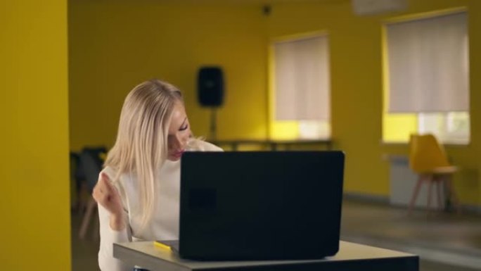 高加索自由职业女性休闲服使用笔记本电脑和平板电脑在工作场所在线工作和听音乐流。快乐的年轻女孩快乐放松