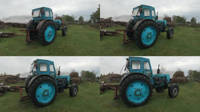 一辆破旧的轮式拖拉机在一个农场后面等待报废