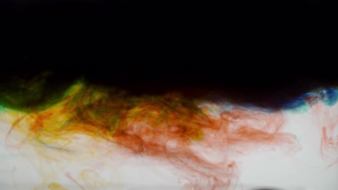 彩色墨水在流入装满水的玻璃罐时形成云状