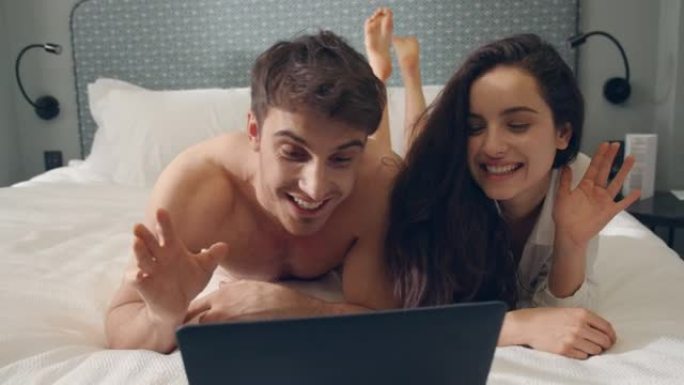 花哨的情侣会说话的笔记本电脑网络摄像头。漂亮的情侣看着电脑屏幕