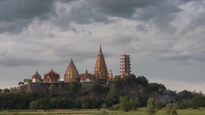 时光流逝的Wat tham sua或tiger cave temple，带有绿色的茉莉稻田，蓝天，阳