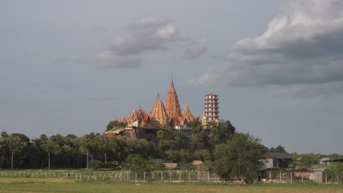 时光流逝的Wat tham sua或tiger cave temple，带有绿色的茉莉稻田，蓝天，阳