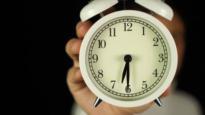 6:30点。人类手持闹钟，显示六点三十分的铃声。