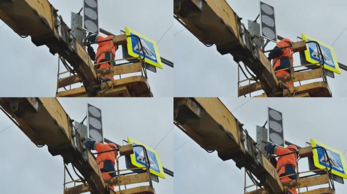 电梯托架中的一名工人修理LED交通信号灯。路标。LED技术。行人过路标志