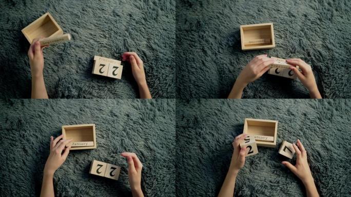 一个男孩的手翻转木质立方体。木制立方体日历
