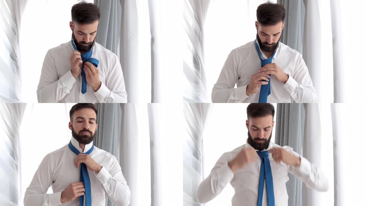 留着胡须的年轻商人男子系好领带，准备在新公司参加新工作面试，或者他是准备婚礼的新郎