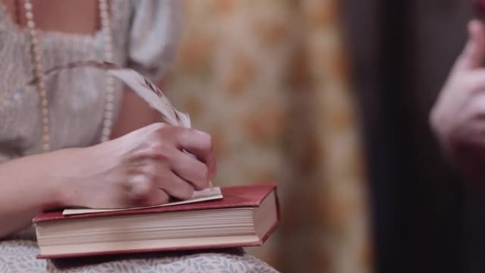 女人穿着古装用羽毛笔写作。