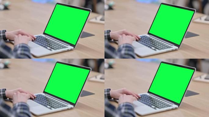 女性手使用带绿色色度键屏幕的笔记本电脑