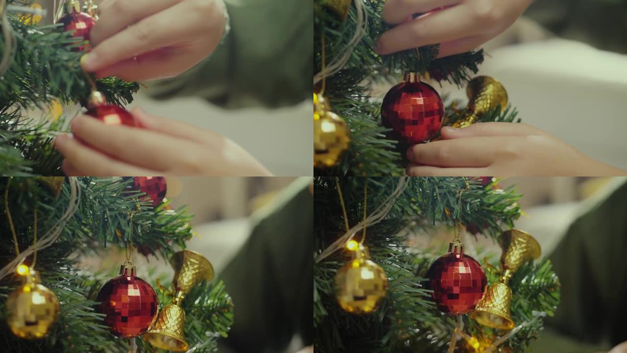 孩子的手在家里的夜晚装饰圣诞树，假期的概念。