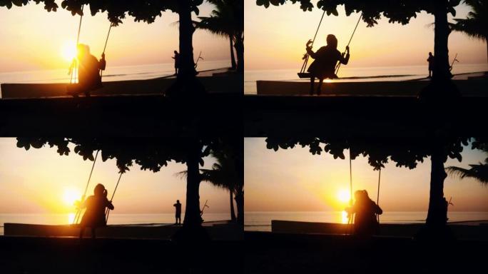 剪影女孩玩秋千，悬挂在日出背景的树上，慢动作。