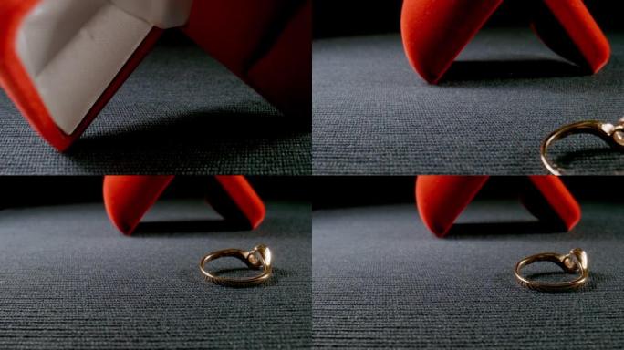 宏观: 带有金戒指的礼盒落在表面上-慢动作