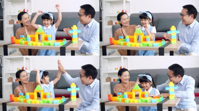 父母与女儿一起玩塑料砖