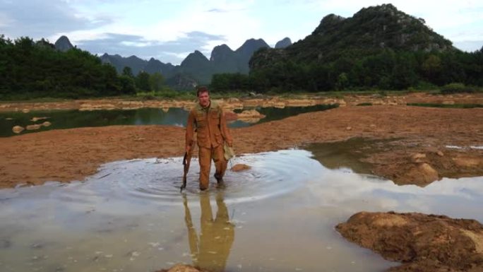 战斗磨损的焊锡在水和泥浆中行走。