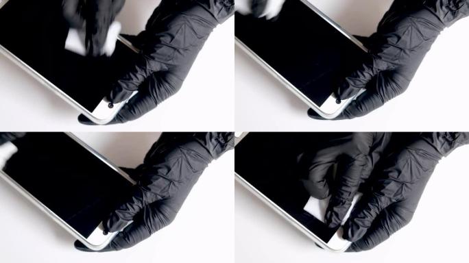 用黑色手套蘸湿纸巾清洁智能手机屏幕或手机显示屏。