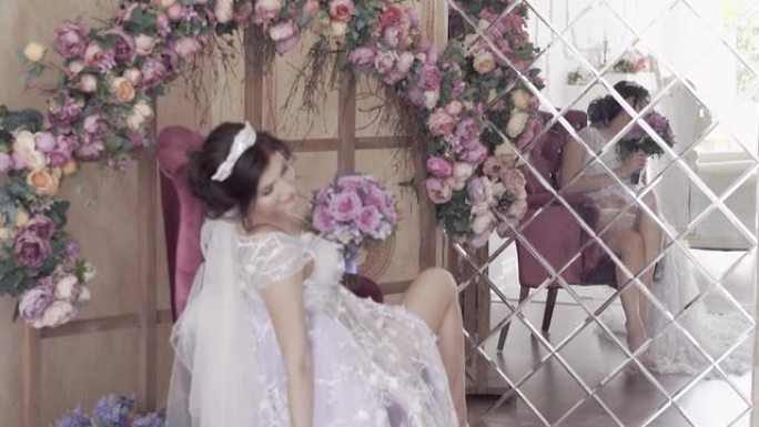 慢动作新娘坐在花拱下对着镜子