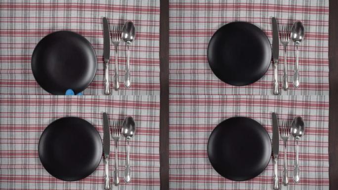 带餐巾和餐具的空黑色盘子。抽象食品背景。